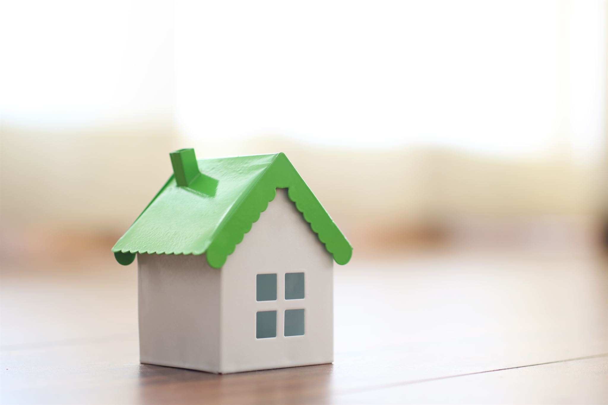 Close-up-of-a-toy-house-with-a-green-roof